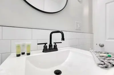 a bathroom sink with a faucet and two glasses on it at Housepitality- The 614 Peaceful Escape - Old Town in Columbus