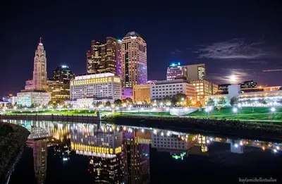 a city skyline at night with a river and buildings at Housepitality- The 614 Peaceful Escape - Old Town in Columbus