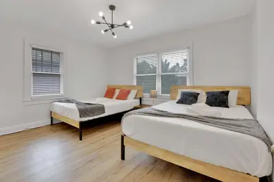 two beds in a room with two windows at Housepitality- The 614 Peaceful Escape - Old Town in Columbus
