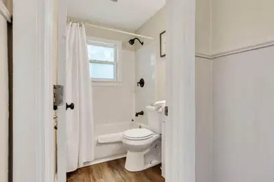 a white bathroom with a toilet and a shower at The Lucky 7's Inn-5 Beds in Columbus