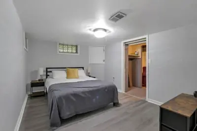 a white bedroom with a bed and a table at The Lucky 7's Inn-5 Beds in Columbus