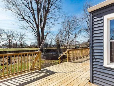 a wooden deck next to a house with a fence at The Lucky 7's Inn-5 Beds in Columbus