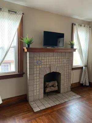 a living room with a fireplace with a tv on top at A2 Executive City View apartment perfect for traveling professionals in Norwood