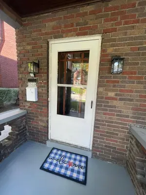 a door with a welcome mat in front of a brick building at A2 Executive City View apartment perfect for traveling professionals in Norwood