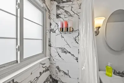 a bathroom with a black and white marble wall at Heated, Cozy 3BR Perfect for Winter Getaways in Columbus