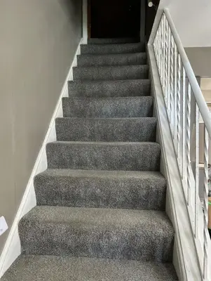 a staircase with grey carpeting and a stair case at Relaxing 4BR Holiday Retreat Large, Cozy & Close to Airport in Columbus