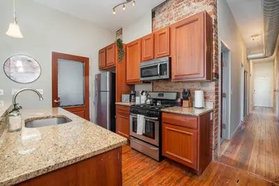 a kitchen with wooden cabinets and a stove top oven at The Reserve - Heart of OTR 2 Bed Suite w/Views in Cincinnati