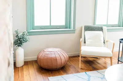 a living room with a chair and a ottoman at The Reserve - Heart of OTR 2 Bed Suite w/Views in Cincinnati