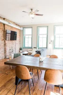 a living room with a large wooden table and chairs at The Reserve - Heart of OTR 2 Bed Suite w/Views in Cincinnati