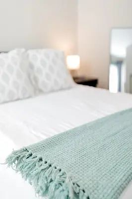 a white bed with a green blanket on it at The Reserve - Heart of OTR 2 Bed Suite w/Views in Cincinnati