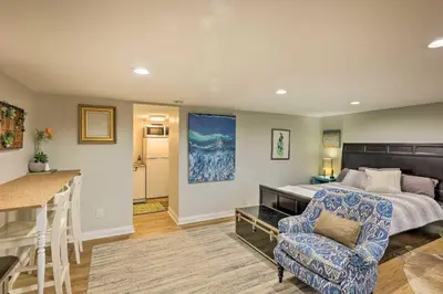 a bedroom with a bed and a chair and a kitchen at Northern Kentucky Studio Near Cincinnati! in Southgate