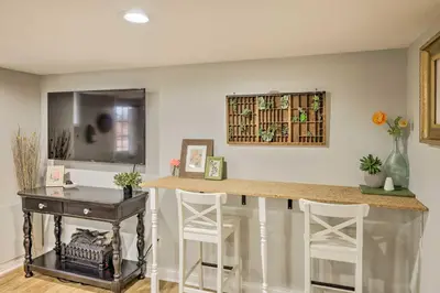 a kitchen with a bar with a desk and stools at Northern Kentucky Studio Near Cincinnati! in Southgate
