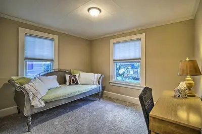 a living room with a couch and two windows at Charming and Family-Friendly Zanesville Home! in Zanesville