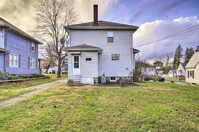 an old white house in the middle of a yard at Charming and Family-Friendly Zanesville Home! in Zanesville
