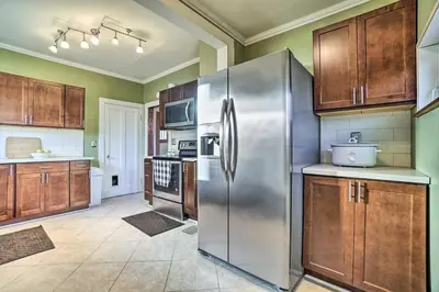 a kitchen with a stainless steel refrigerator and wooden cabinets at Charming and Family-Friendly Zanesville Home! in Zanesville