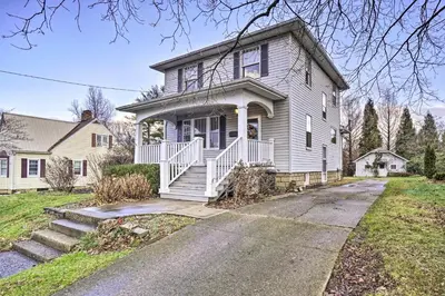a white house with a porch and a driveway at Charming and Family-Friendly Zanesville Home! in Zanesville