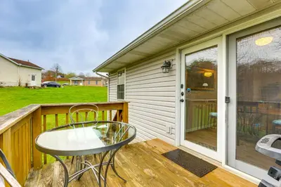 a patio with a table and chairs on a deck at Renovated Logan Home with Pond and Fire Pit in Logan