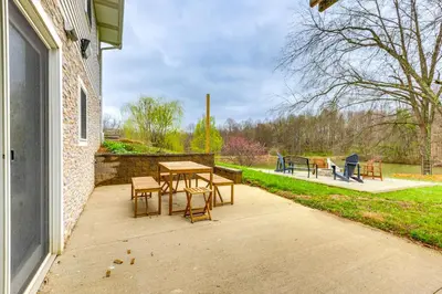 a patio with a table and chairs in a park at Renovated Logan Home with Pond and Fire Pit in Logan