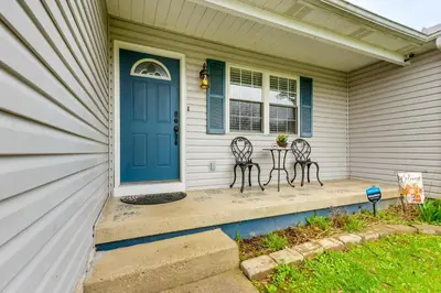 a porch with two chairs and a blue door at Renovated Logan Home with Pond and Fire Pit in Logan