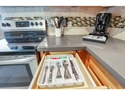 a kitchen counter with utensils in a drawer at Housepitality - Little River Trails in Mason