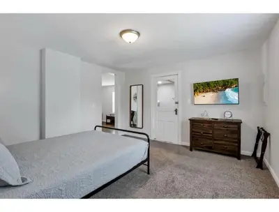a bedroom with a bed and a wooden dresser at Housepitality - Little River Trails in Mason