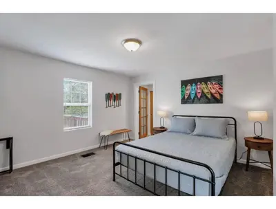 a white bedroom with a bed and a window at Housepitality - Little River Trails in Mason