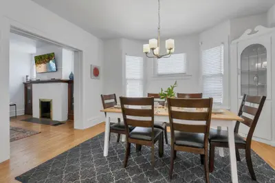 a dining room with a table and chairs and a fireplace at Housepitality - The Maynard Manor in Columbus