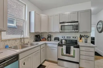 a kitchen with white cabinets and stainless steel appliances at Housepitality - The Maynard Manor in Columbus