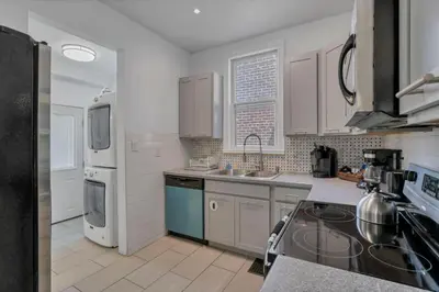 a kitchen with a sink and a refrigerator at Housepitality - The Maynard Manor in Columbus