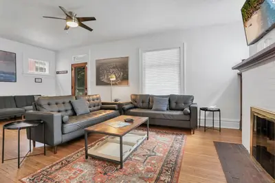 a living room with two couches and a fireplace at Housepitality - The Maynard Manor in Columbus
