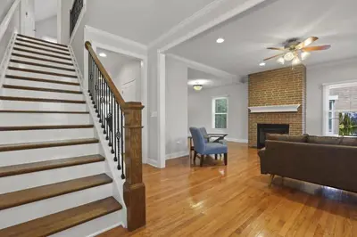 a living room with a staircase and a couch at Housepitality - The Victorian Vacation Home in Columbus