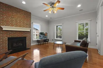 a living room with a fireplace and a ceiling fan at Housepitality - The Victorian Vacation Home in Columbus