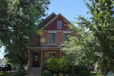 a red brick house with trees in front of it at Housepitality - The Victorian Vacation Home in Columbus