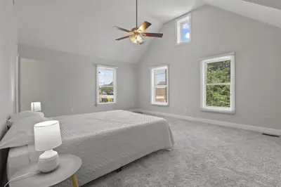 a white bedroom with a bed and a ceiling fan at Housepitality - The Victorian Vacation Home in Columbus