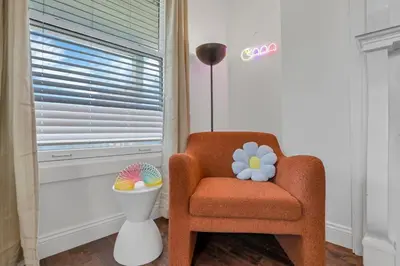 an orange chair in a room with a lamp at Housepitality - The Columbus Game House - 2 BR in Columbus