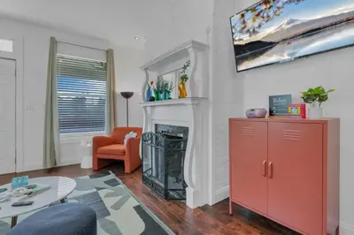 a living room with a fireplace and a orange chair at Housepitality - The Columbus Game House - 2 BR in Columbus