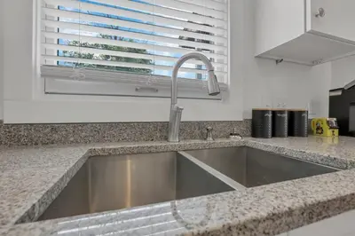 a kitchen counter with a sink and a window at Housepitality - The Columbus Game House - 2 BR in Columbus