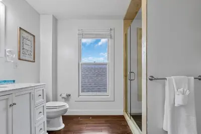 a white bathroom with a window and a toilet at Housepitality - The Columbus Game House - 2 BR in Columbus