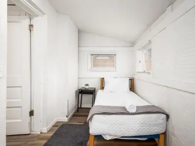 a small bedroom with a bed and a table at Large 5 Bedroom House Next to OSU, Sleeps 16 in Columbus