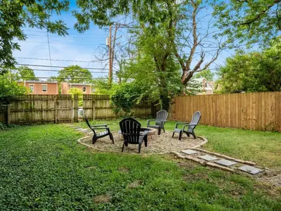 three chairs and a table in a yard with a fence at Large 5 Bedroom House Next to OSU, Sleeps 16 in Columbus