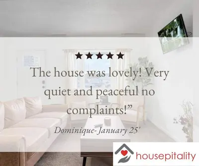 a living room with a white couch and four stars at Housepitality - The Southside Ranch in Columbus