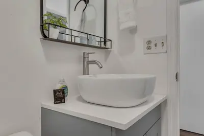 a white bathroom with a sink and a mirror at Housepitality - The Southside Ranch in Columbus