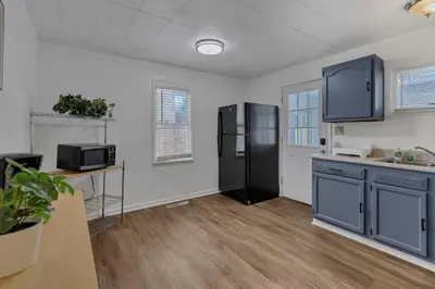 a kitchen with blue cabinets and a black refrigerator at Housepitality - The Southside Ranch in Columbus