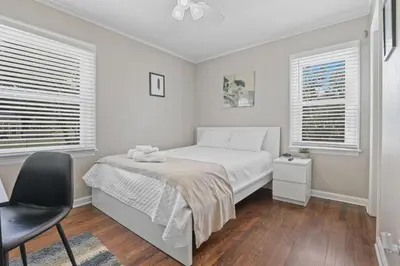 a bedroom with a bed and two windows at Housepitality- The Bungalow -2 BR in Columbus