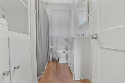 a white bathroom with a toilet and a sink at Housepitality- The Bungalow -2 BR in Columbus