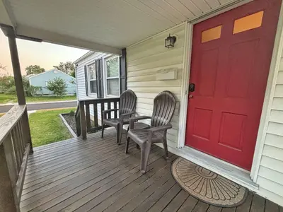 a porch with two chairs and a red door at Housepitality- The Bungalow -2 BR in Columbus