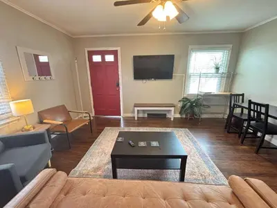 a living room with a couch and a red door at Housepitality- The Bungalow -2 BR in Columbus