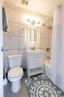 a bathroom with a toilet and a sink and a tub at Georgetown Villas Two Bedroom 3-2a Apartment in Fairview Park, Ohio! in Fairview Park
