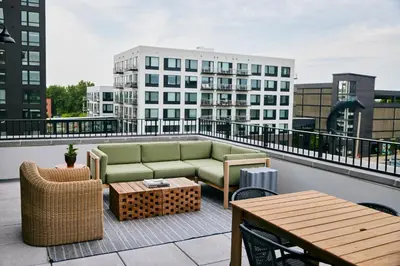 a patio with a couch and tables on a balcony at The Junto Hotel in Columbus