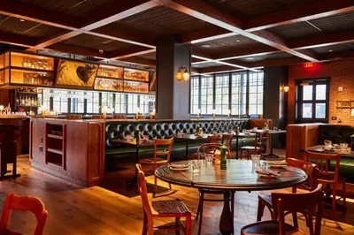 a restaurant with tables and chairs and a bar at The Junto Hotel in Columbus